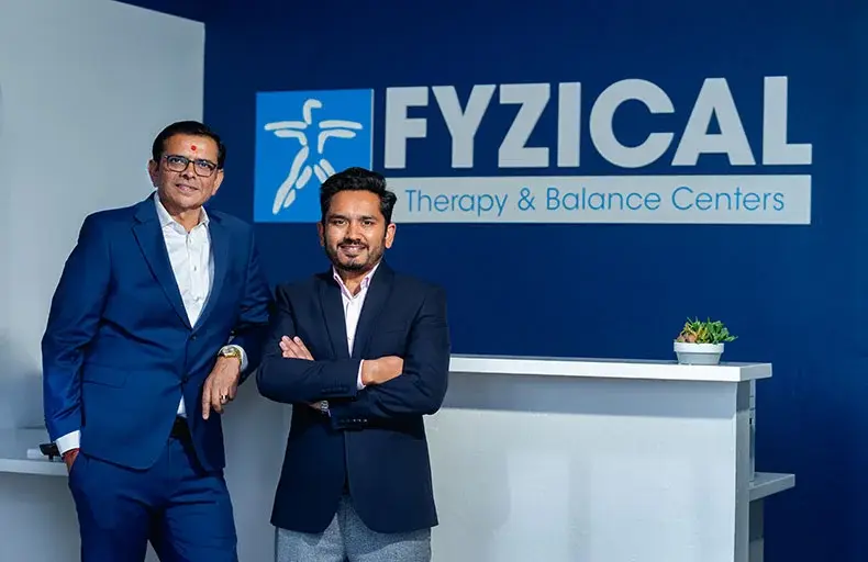 Entrepreneur Jignesh Domadia and Physical Therapist Jiten Dungarani standing in front of Fyzical sign