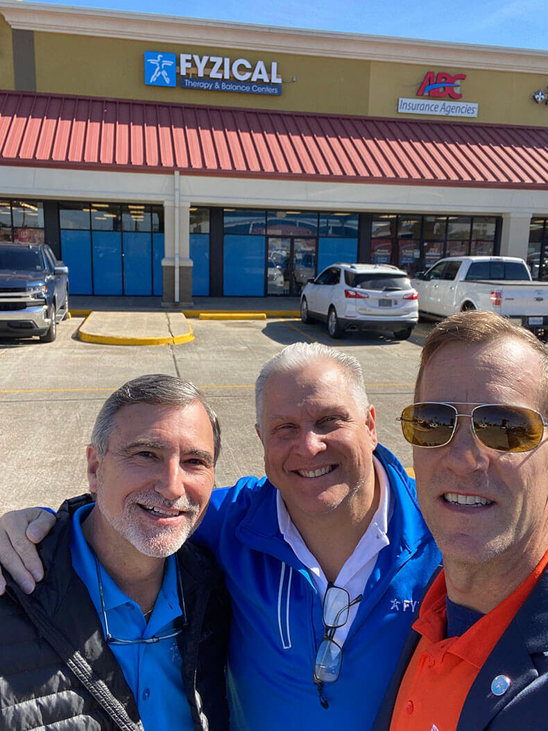 three men taking a selfie in a parking lot